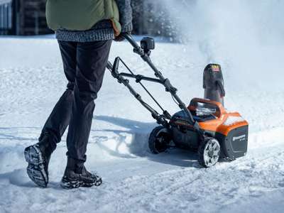 En person rydder snø med en Husqvarna ST 143i.