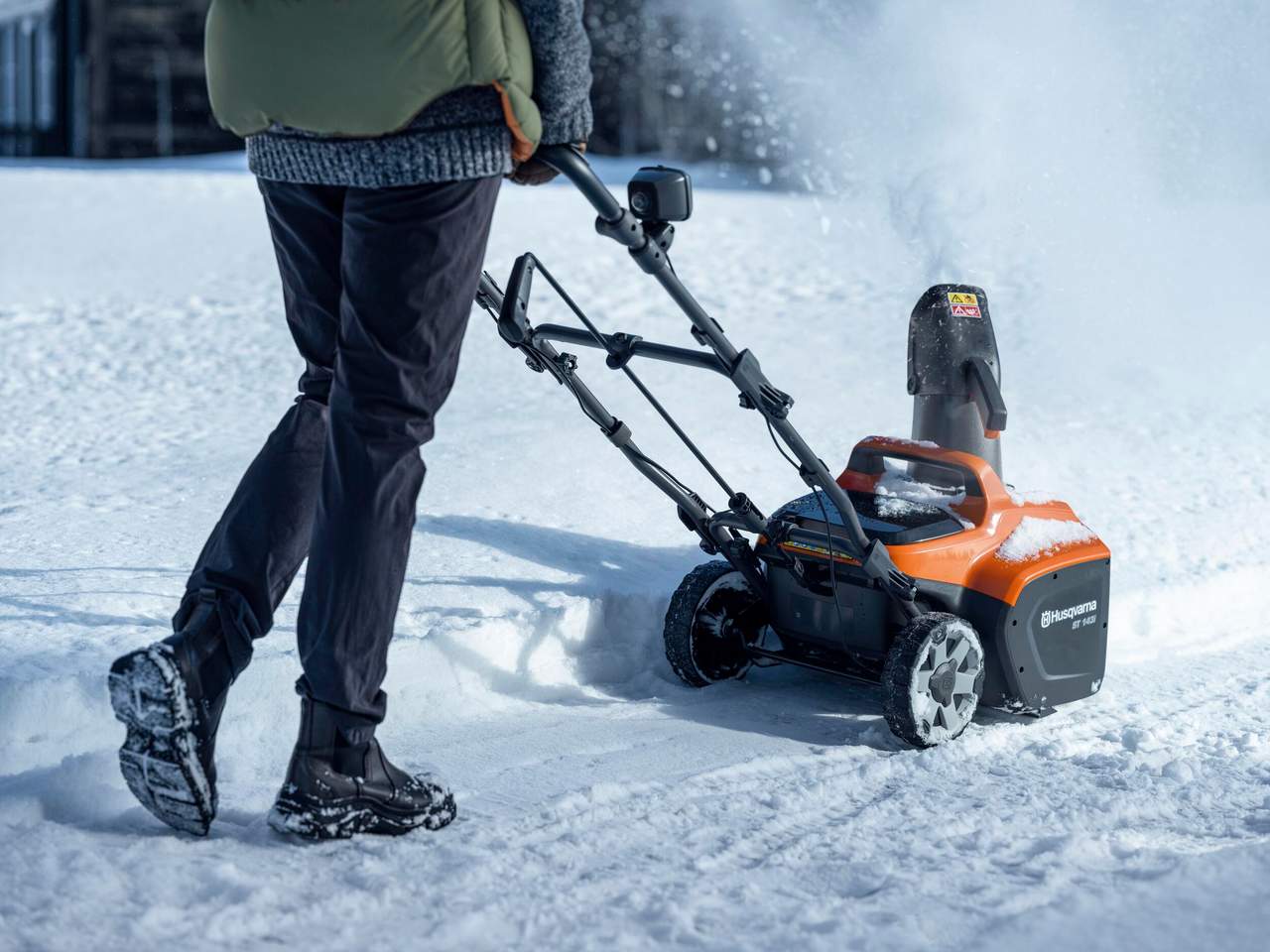 En person rydder snø med en Husqvarna ST 143i.