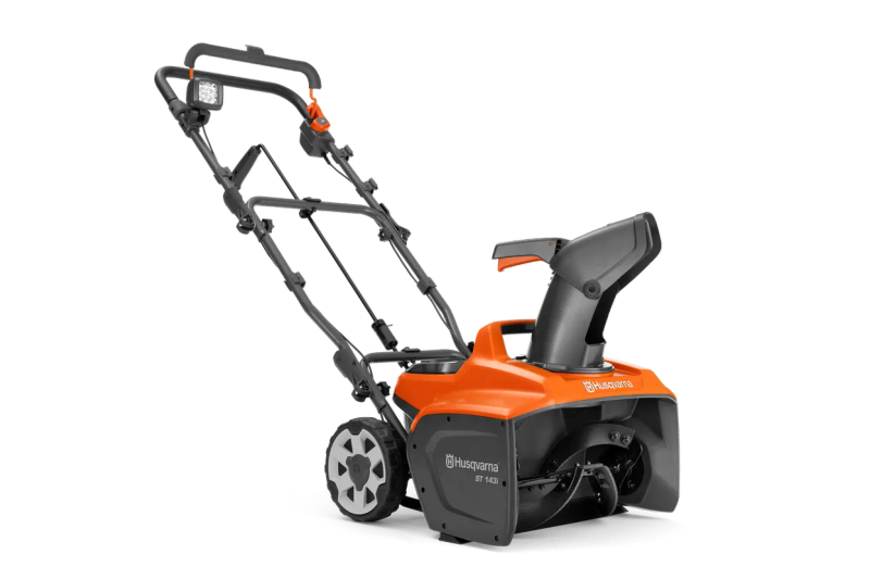 Husqvarna ST 143i sett skrått forfra, med håndtak, utkaster og innmatingsåpning synlig.